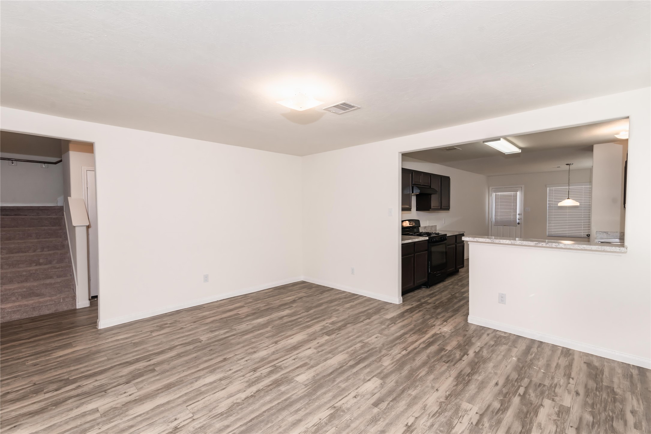 5312 Rio Ramos Street Rosharon, TX 77583 - Photo 5 of 11 a view of kitchen and empty room with wooden floor