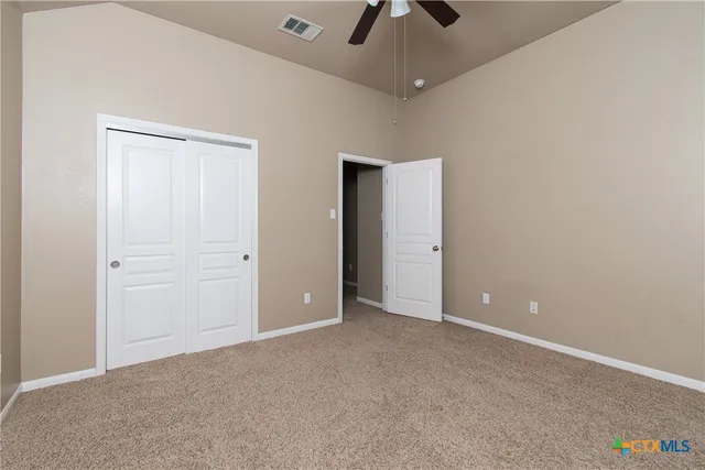 an empty room with chandelier fan