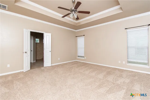 an empty room with windows and fan