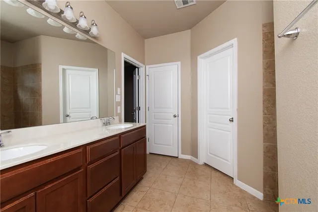 a bathroom with a double vanity sink and a mirror
