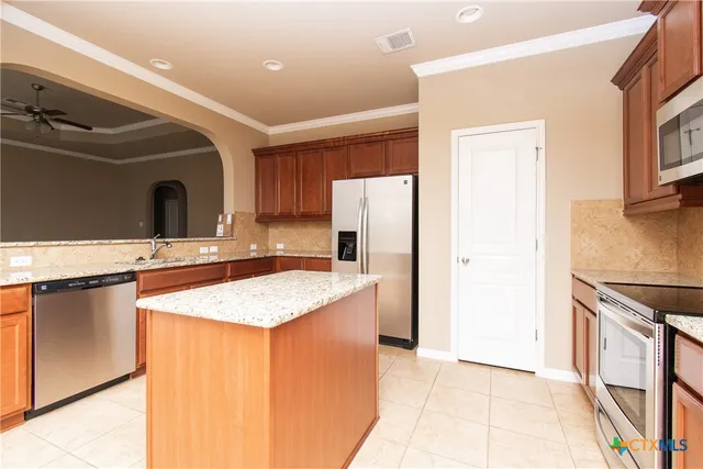 a kitchen with stainless steel appliances granite countertop a sink and a refrigerator