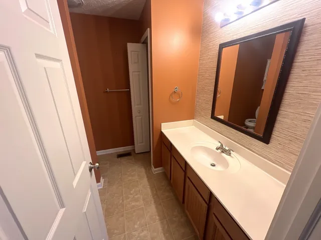 a bathroom with a sink and mirror with toilet