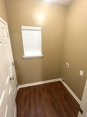 a view of a room with wooden floor and a window