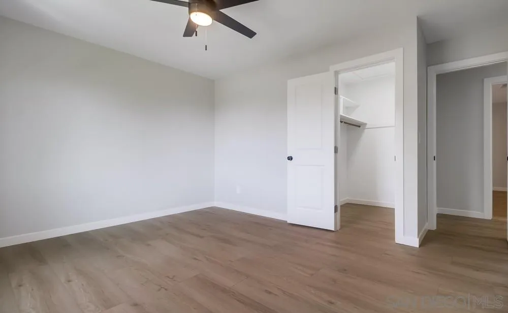 8174 Sunset Road Lakeside, CA 92040 - Photo 30 of 46 an empty room with wooden floor and ceiling fan