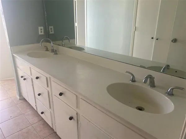 a bathroom with a double vanity sink and mirror