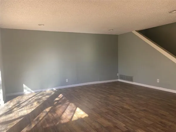 an empty room with wooden floor and fireplace