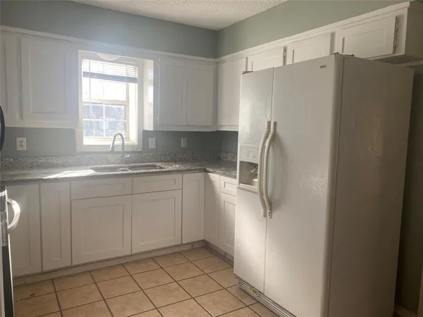 a kitchen with stainless steel appliances a refrigerator sink and cabinets