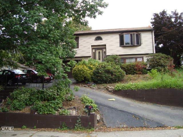 a front view of a house with a yard and potted plants