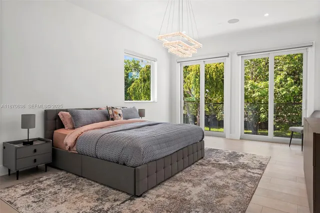 a bedroom with a bed lamp and a large window