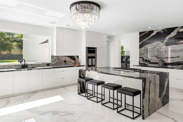 a kitchen with granite countertop stainless steel appliances a sink and a stove