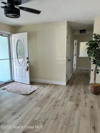 an empty room with wooden floor and mirror