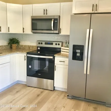 a kitchen with stainless steel appliances granite countertop a refrigerator sink and stove