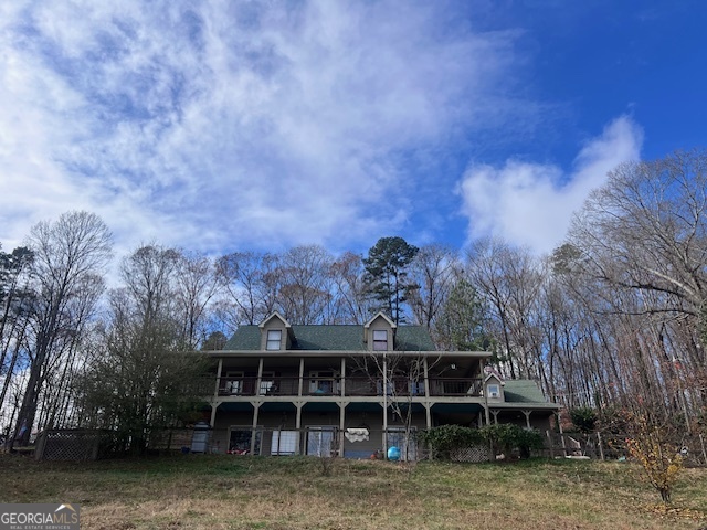 a view of a house with a large window and a yard with trees