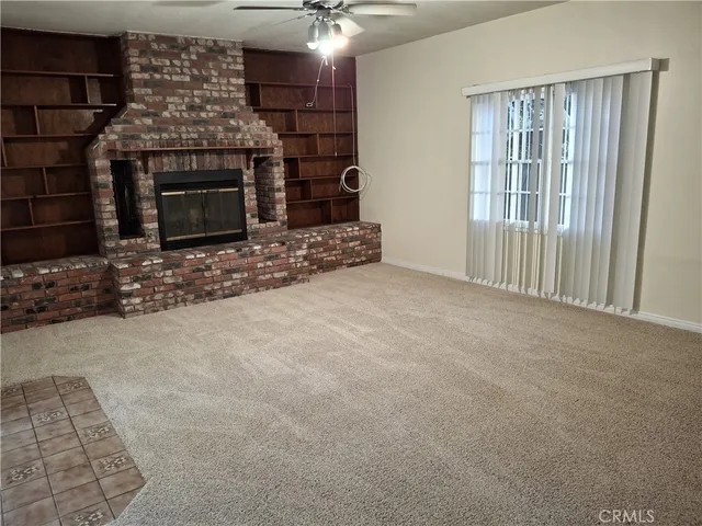 a view of empty room with fireplace and fan