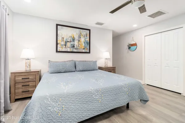 a bedroom with a bed and a painting on the wall