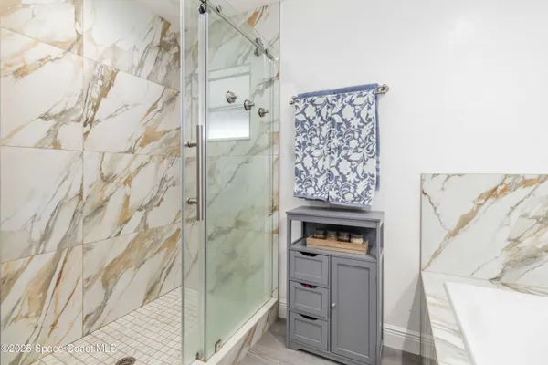 a view of bathroom with bathtub and shower