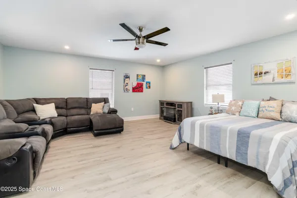 a spacious bedroom with a bed a couch and a window