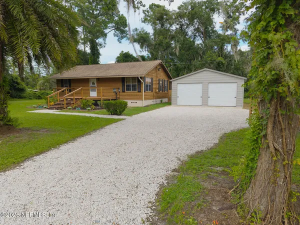 a front view of a house with a yard and trees