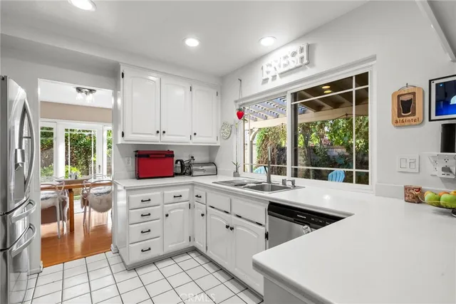 a open kitchen with stainless steel appliances a stove a sink and a refrigerator
