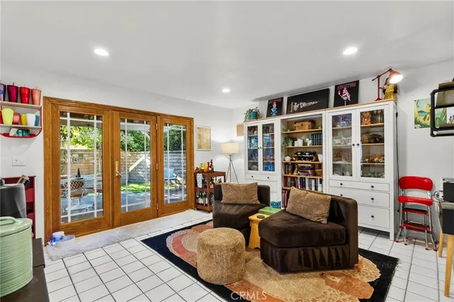 a living room with furniture a bookshelf and a large window