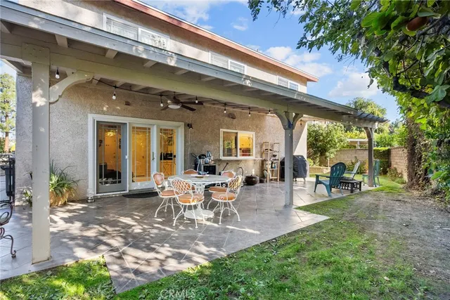 a view of a patio with table and chairs and a large tree