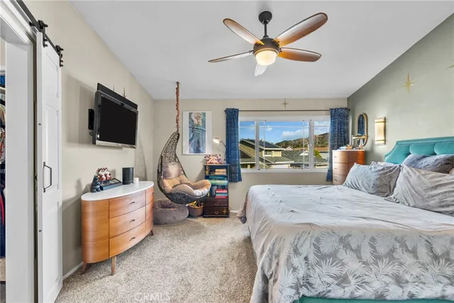 a bedroom with a bed couch and a flat tv screen