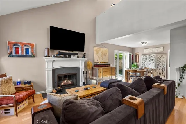a living room with furniture a flat screen tv and a fireplace