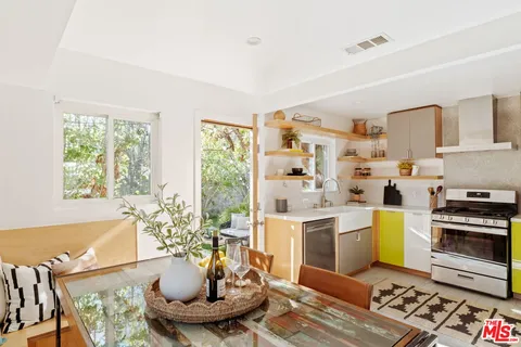 a kitchen with a stove a sink and a dining table with kitchen view