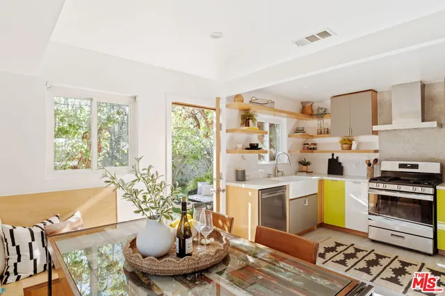 a kitchen with a stove a sink and a dining table with kitchen view