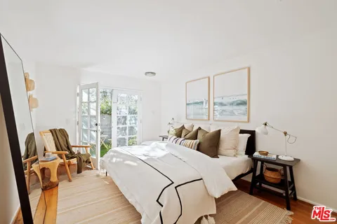 a bedroom with a bed a chair and next to a window