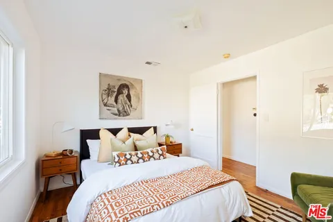 a bedroom with a bed and wooden floor