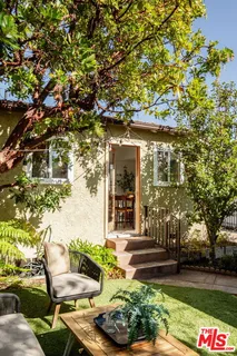 a backyard of a house with table and chairs