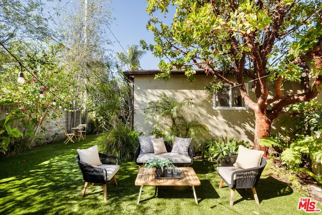 a view of a chair and table in backyard of the house