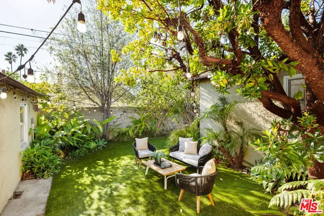 a view of a yard with plants and sitting area