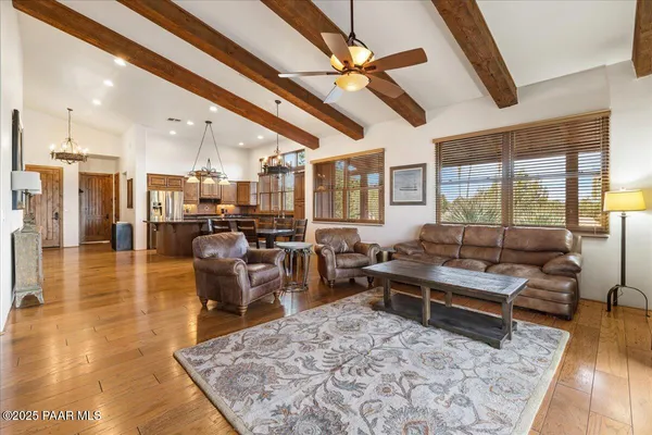 a bedroom with a bed couches and a flat tv screen