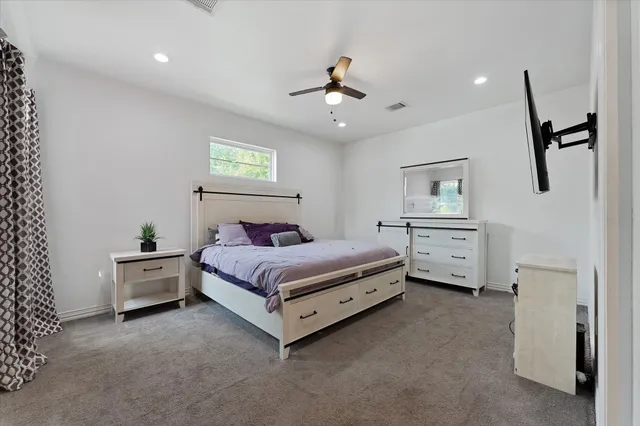 a spacious bedroom with a bed and a cabinets