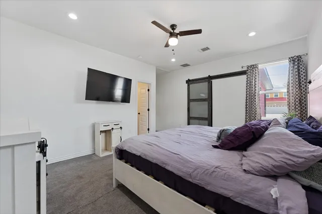 a bedroom with a bed window and a flat screen tv