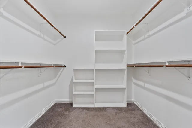 a view of walk in closet with empty racks