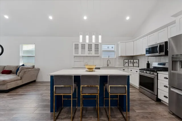 a kitchen with a table chairs microwave and cabinets