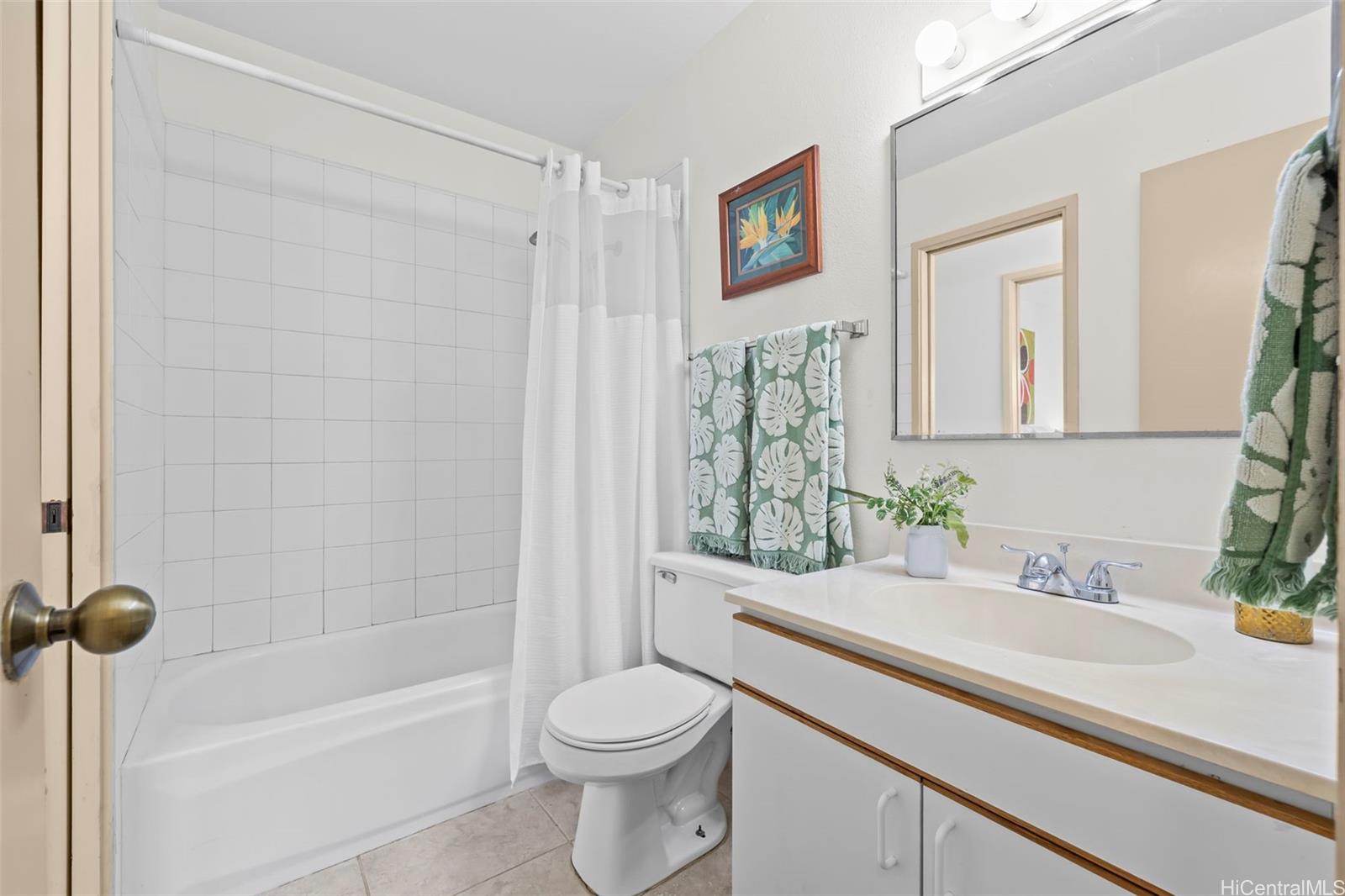 91-1008 Makaaloa Street, Unit 3E Ewa Beach, HI 96706 - Photo 18 of 21 a bathroom with a sink a toilet and a bathtub