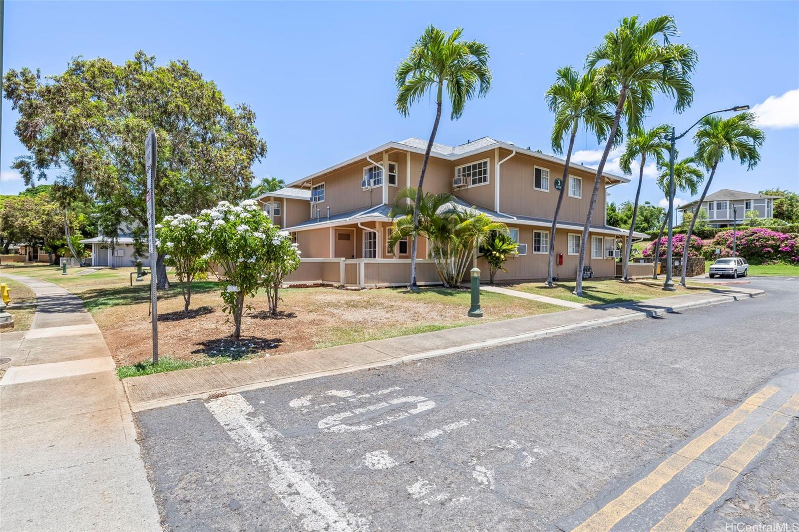 91-1008 Makaaloa Street, Unit 3E Ewa Beach, HI 96706 - Photo 20 of 21 a front view of a building with palm trees
