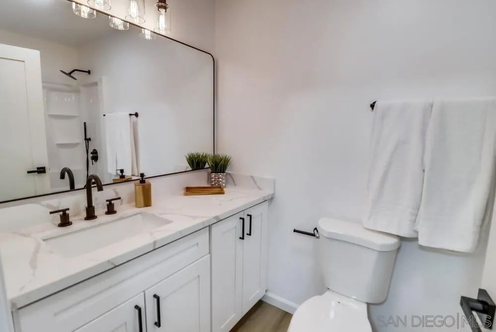 2821-25 Rosedale Way Spring Valley, CA 91977 - Photo 22 of 72 a bathroom with a sink and mirror with toilet