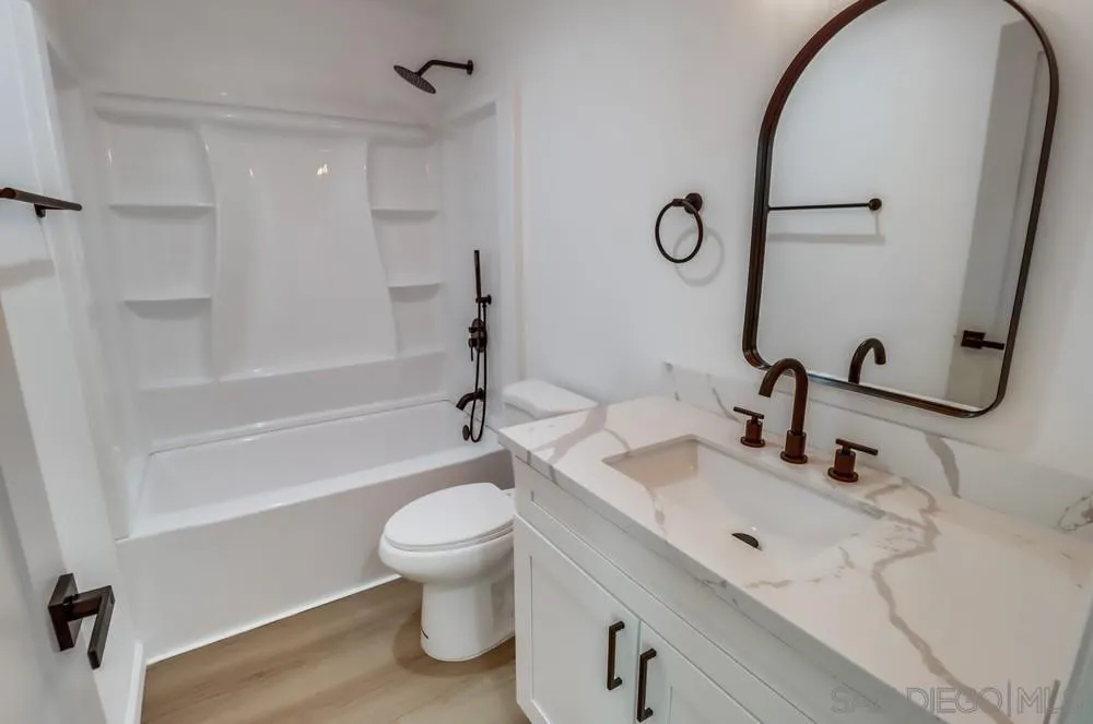 2821-25 Rosedale Way Spring Valley, CA 91977 - Photo 44 of 72 a bathroom with a sink a toilet and a mirror