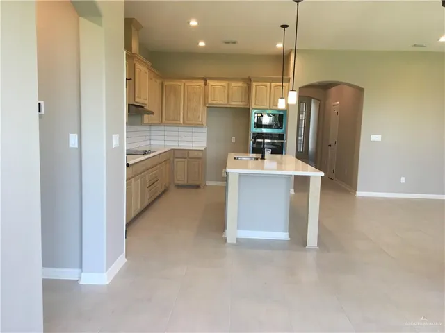 a large kitchen with a sink a refrigerator and a stove