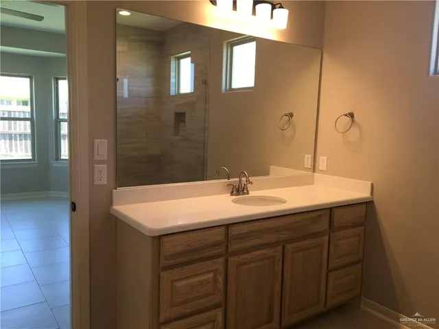 a bathroom with a sink vanity granite and a mirror