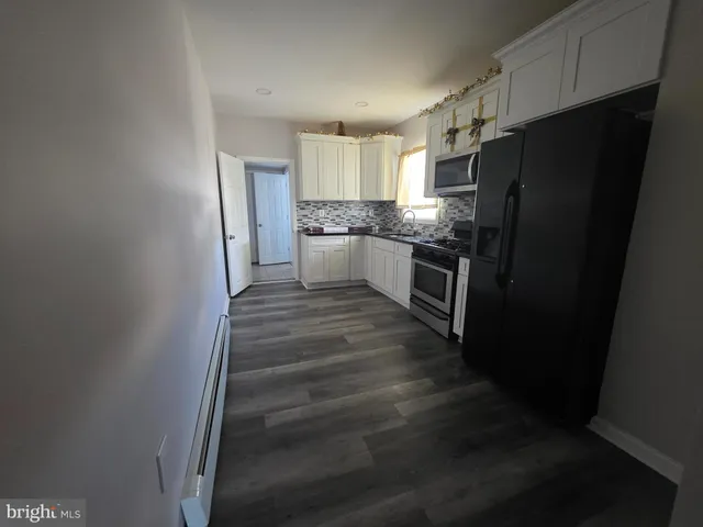 a kitchen with granite countertop white cabinets and stainless steel appliances