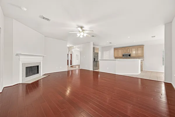 a view of an empty room with a window and wooden floor