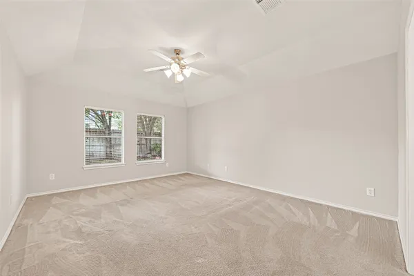 a view of an empty room with a chandelier fan