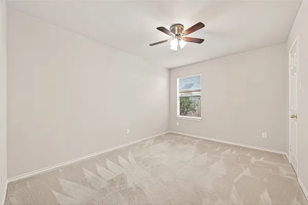 an empty room with chandelier fan