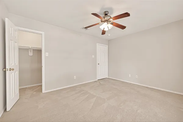 an empty room with closet and windows